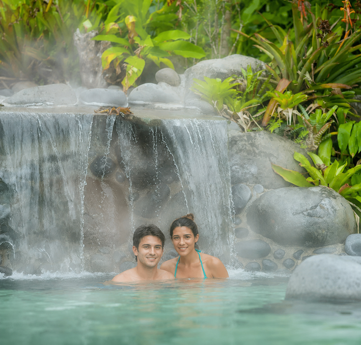 Pareja relajándose en aguas termales rodeadas de selva, La Fortuna