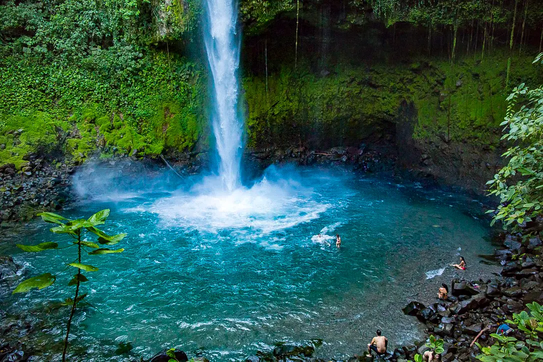Bañistas en la poza turquesa de la Catarata La Fortuna