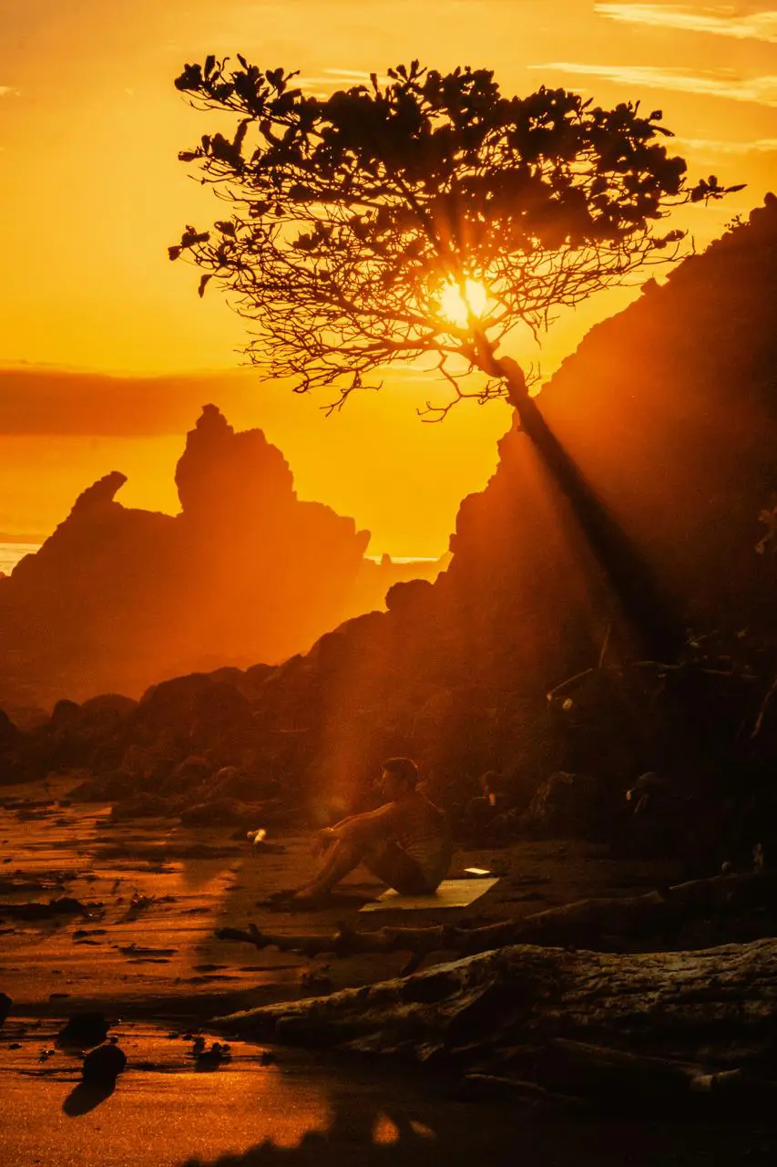 Sunset light breaking through the rocks at the south end of Jacó beach