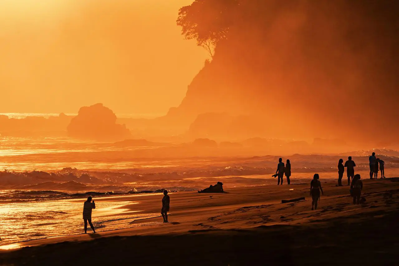 Evening walk on Jacó beach under an orange sky