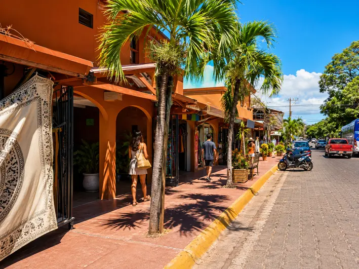 Tiendas y palmeras sobre la calle principal de Tamarindo